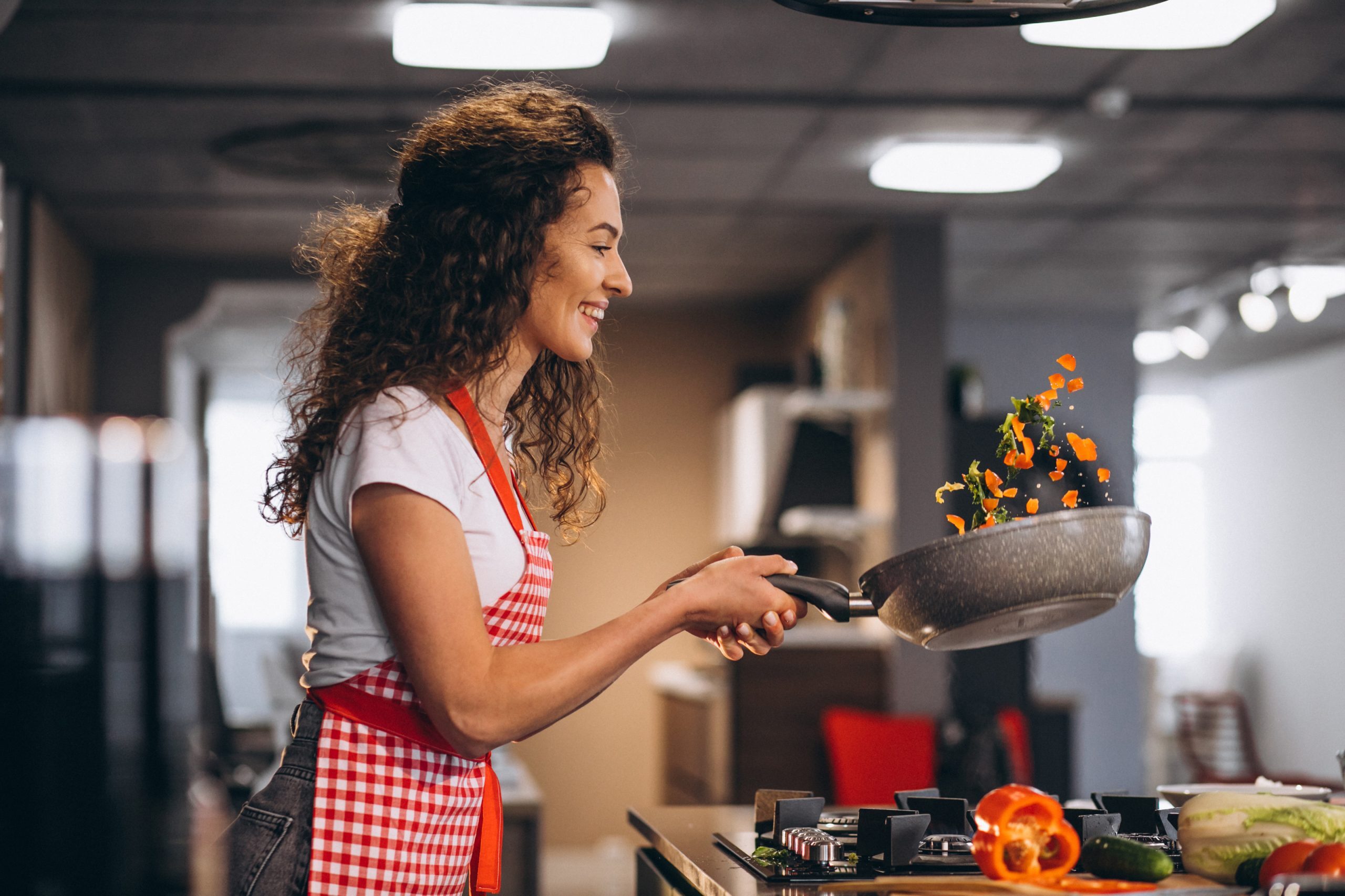 woman-chef-cooking-vegetables-pan-scaled